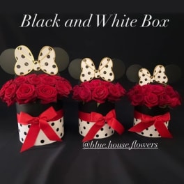 Three red rose arrangements in black-and-white polka dot boxes with red bows