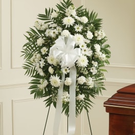 White funeral wreath with daisies and carnations on a stand