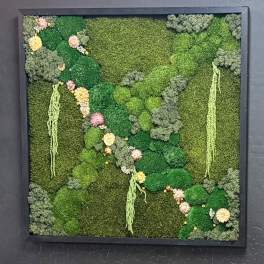 Framed green moss wall with small pastel flowers