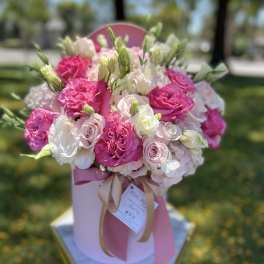 Pink and white rose bouquet in a pink hat box with ribbon