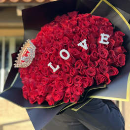 Large bouquet of red roses with LOVE letters and a jeweled brooch