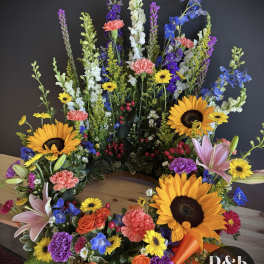 Large colorful floral wreath with sunflowers, lilies, and mixed blooms