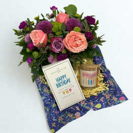 Mixed pink and purple flower bouquet with a birthday candle and card
