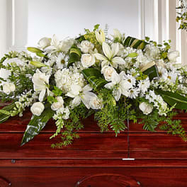 White floral casket spray with lilies and roses