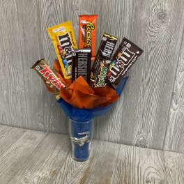 Candy bars arranged in a blue vase with orange and blue wrap