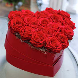 Heart-shaped red box filled with tightly packed red roses