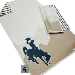 Folded beige and white blanket with a horse-and-rider graphic