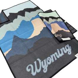 Folded towels with a mountain pattern and the word Wyoming