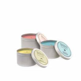 Three scented candles in gray tins with pastel lids