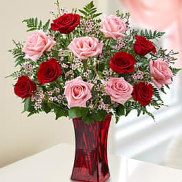 Bouquet of red and pink roses in a red glass vase