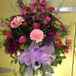 Large bouquet of pink and purple flowers with a lavender ribbon