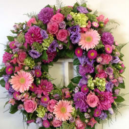 Large pink and purple floral wreath with gerbera daisies and roses