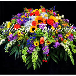 Large colorful floral spray with roses, sunflowers, and purple blooms on a black background