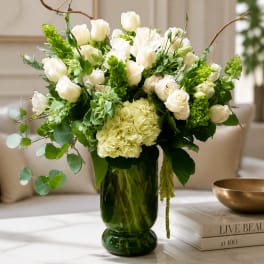 White roses and hydrangea in a green glass vase