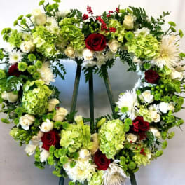 Heart-shaped floral wreath with red and white roses and green hydrangeas