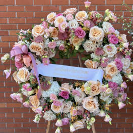 Heart-shaped floral wreath on an easel with pink and peach roses