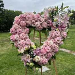 Pink floral heart wreath on a wooden easel outdoors