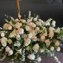 Large white floral spray with roses and lilies on the floor