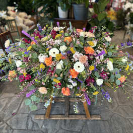 Large colorful floral spray on a wooden stand