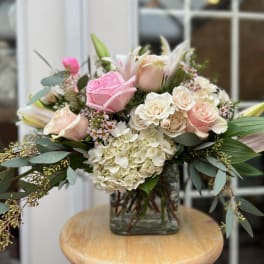 Pink and cream rose bouquet in a square glass vase