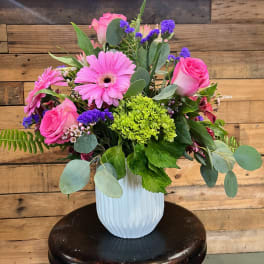 Pink roses and gerbera daisies in a white vase