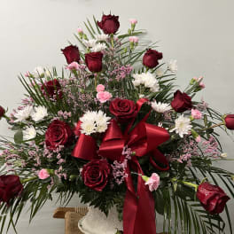 Large bouquet of red roses and white daisies with a red ribbon