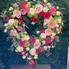 Heart-shaped floral wreath of pink, white, and peach roses