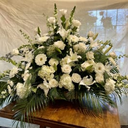 Large white floral arrangement with roses, lilies, and daisies