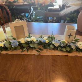 Low floral garland with white and blue blooms on a table