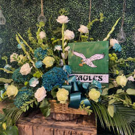 Large floral arrangement with white roses and blue hydrangeas in a basket