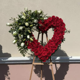 Heart-shaped red and white rose wreath on a wooden easel