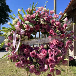 Large pink floral wreath on an easel with a ribbon banner