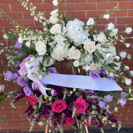 Large floral standing arrangement with white and pink blooms on an easel