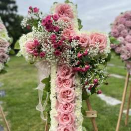 Large cross-shaped floral arrangement with pink roses and white blooms