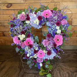 Heart-shaped floral wreath with pink, purple, and white blooms