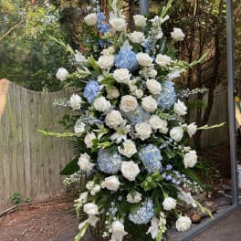 Large standing floral spray with white roses and blue hydrangeas