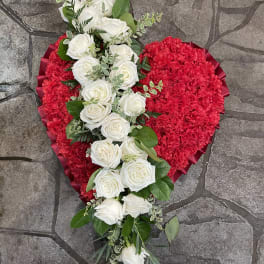 Heart-shaped red floral arrangement with white roses and greenery