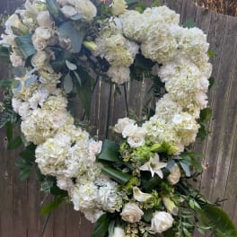 Large white floral heart wreath on a stand
