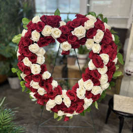 Heart-shaped wreath of red and white roses on a stand