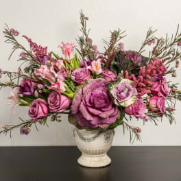 Pink and purple floral arrangement in a white vase