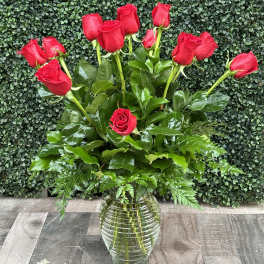 Red roses arranged in a clear glass vase