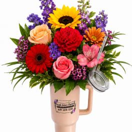 Colorful bouquet in a handled tumbler with a clear lid and straw
