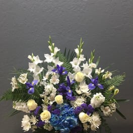White and blue floral arrangement in a white vase