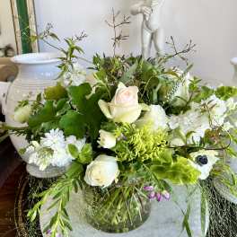 White and pale green floral arrangement in a glass vase