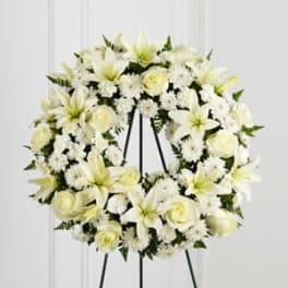 White floral wreath on a black easel stand
