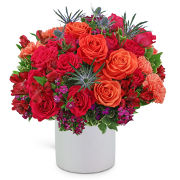 Bright bouquet of red and orange roses in a white vase