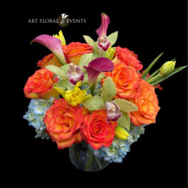 Orange roses with orchids and calla lilies in a glass vase