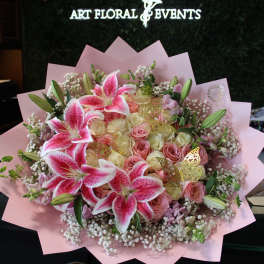 Pink and white bouquet with lilies and roses wrapped in pink paper