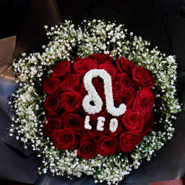 Red roses arranged with white baby's breath in black wrapping