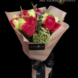 Bouquet of pink and pale yellow roses wrapped in blush paper